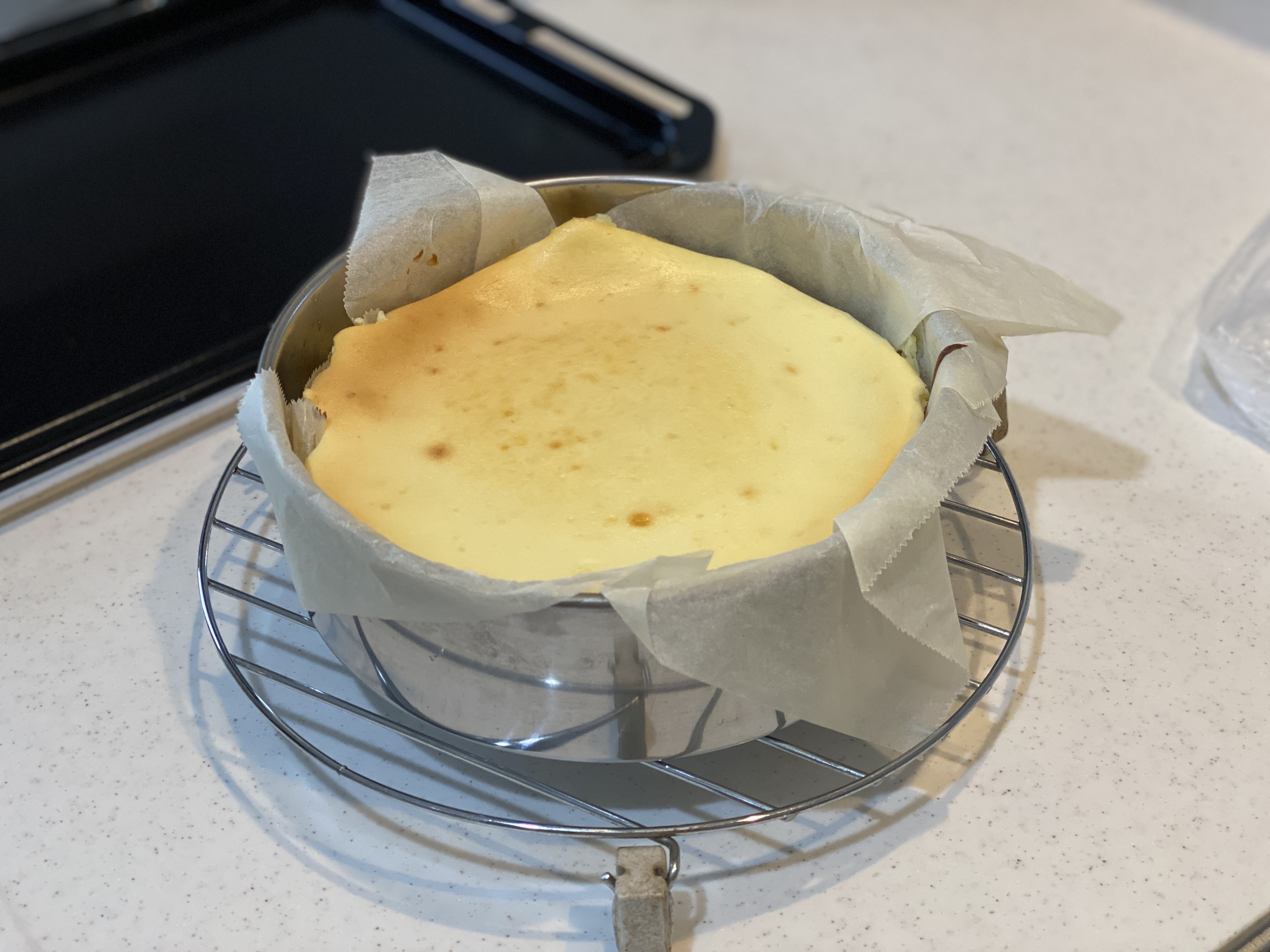 焼き上がったチーズケーキを型ごと網にのせたところ