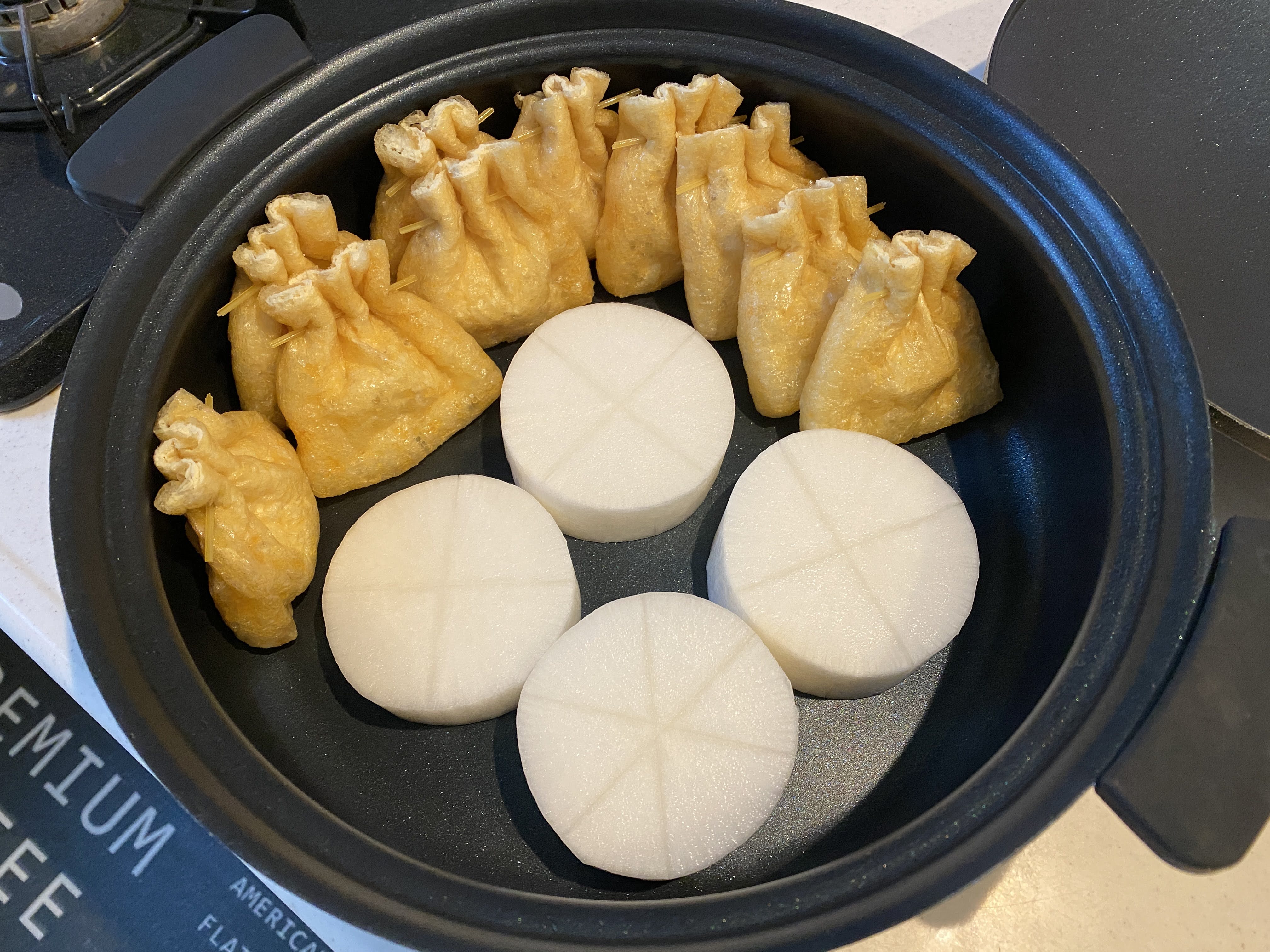輪切りの大根と、半分に切った餅を入れてパスタで留めた餅巾着